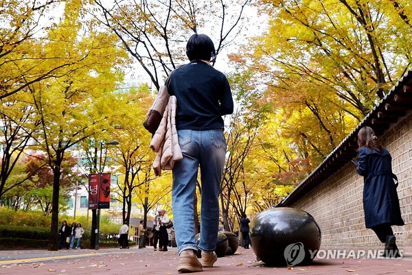 절기상 입동(立冬)을 하루 앞두고 서울 낮 기온이 20도에 육박하며 포근했던 6일 서울 중구 정동길에서 한 시민이 겉옷을 팔에 걸친 채 산책하고 있다.(사진=연합뉴스) 